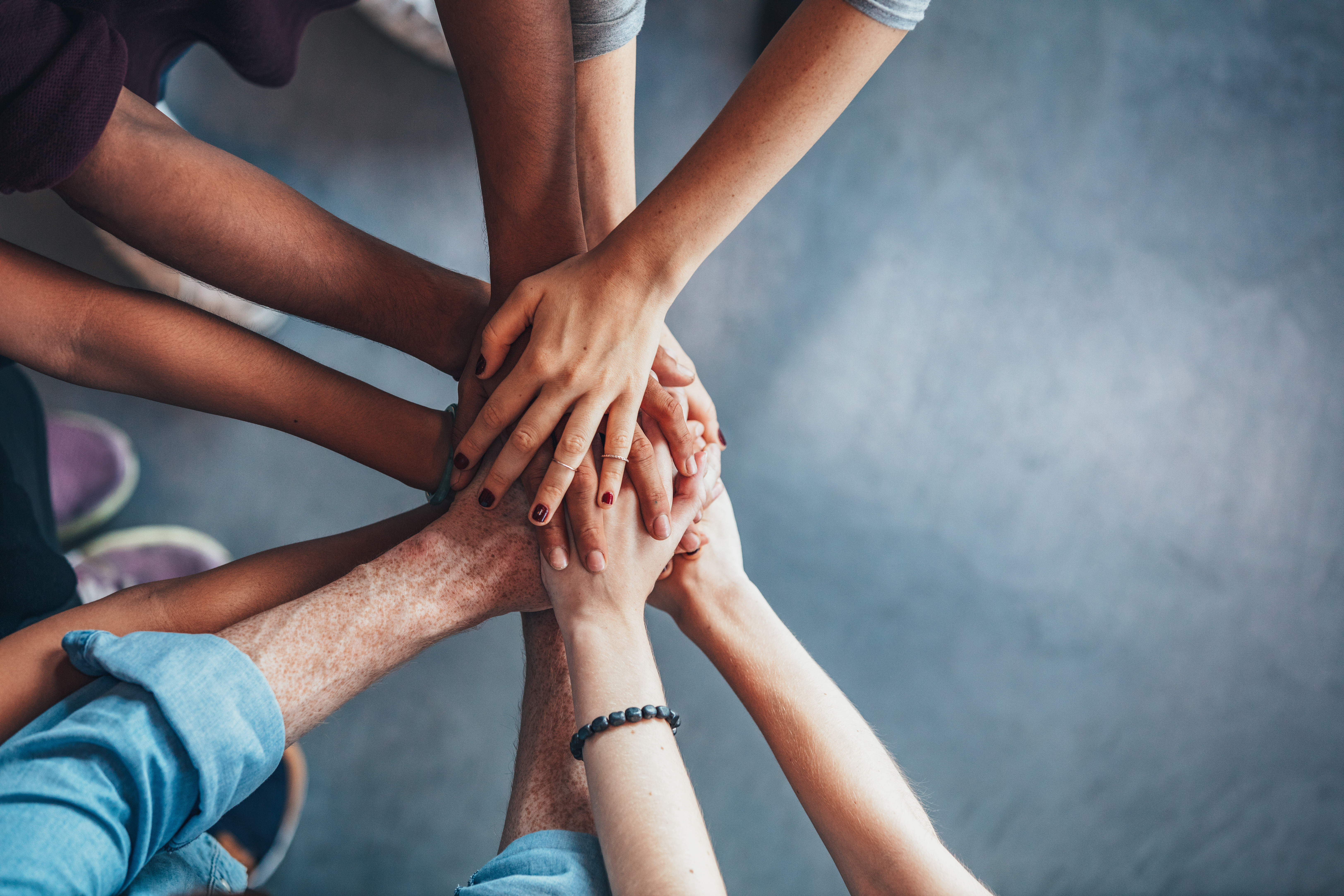 Hands of several people stacked together