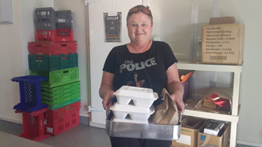 Picture of volunteer carrying takeaway meals